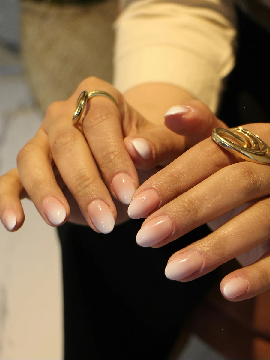 Primo piano della manicure ombre con Shellac di una cliente nelle classiche tonalità nude, subito dopo l’appuntamento in salone