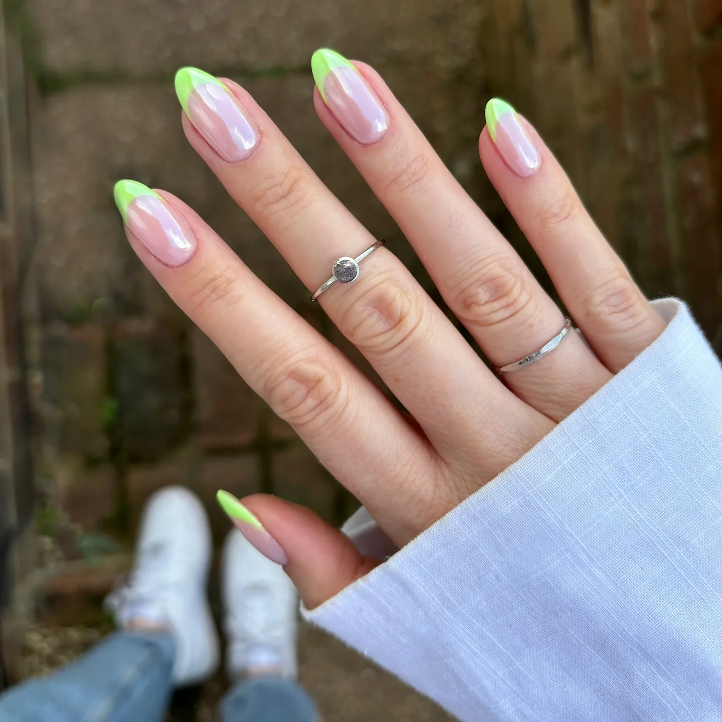 Unghie a mandorla con punte french verde lime su una base cromata perlata e glassata.