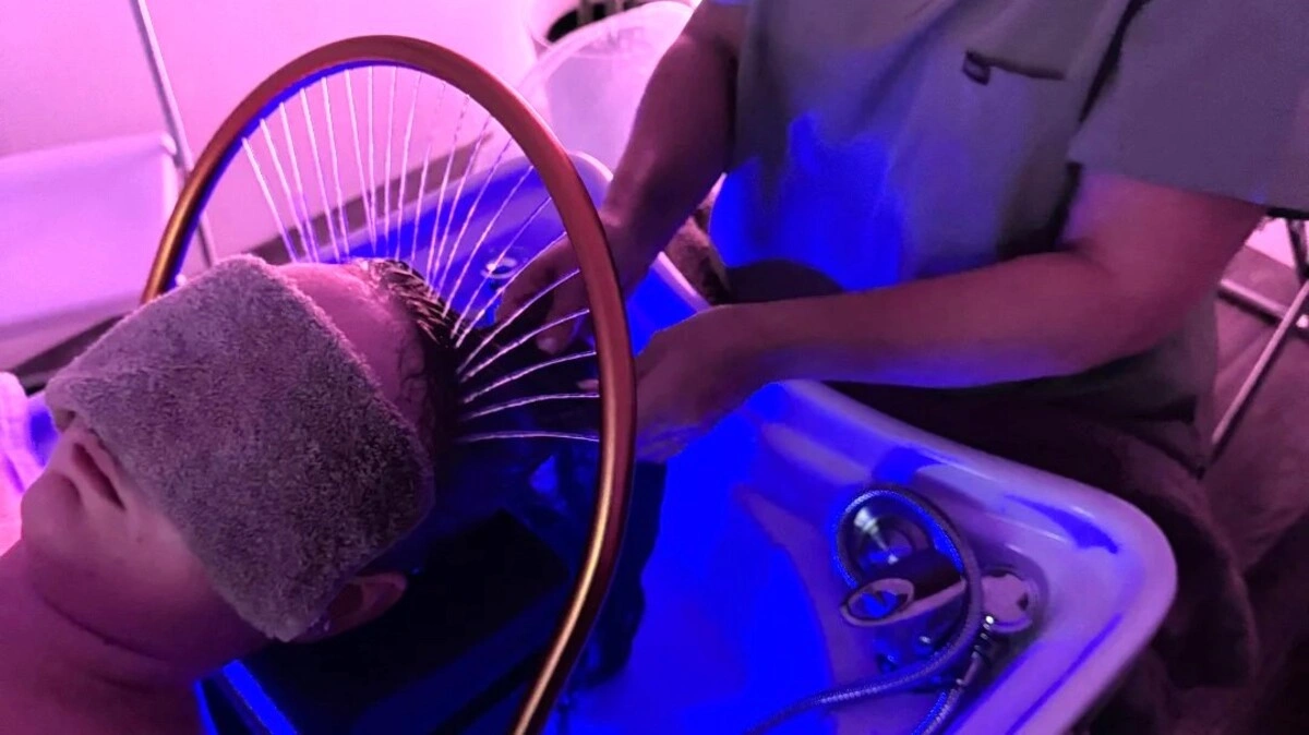 Veduta dall'alto di un professionista che lava i capelli di una cliente durante un head spa giapponese