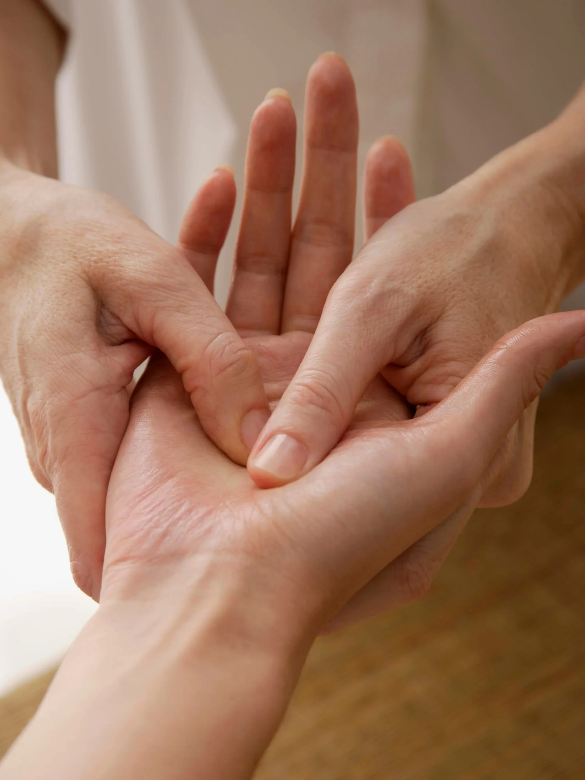 Primo piano di una riflessologa che tratta la mano di una cliente