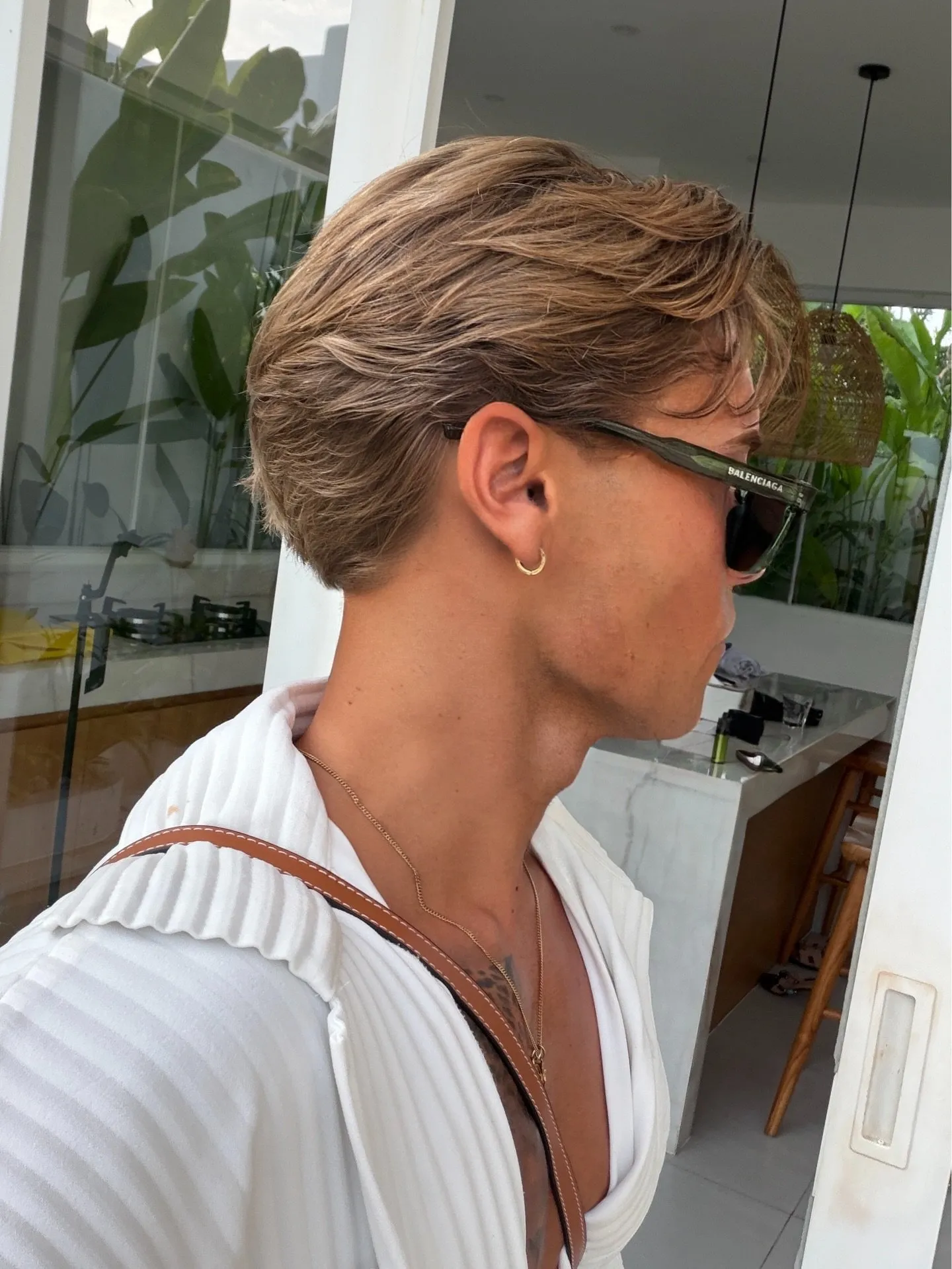 Profilo di un taglio uomo flow testurizzato, ciocche pettinate all'indietro e movimento naturale