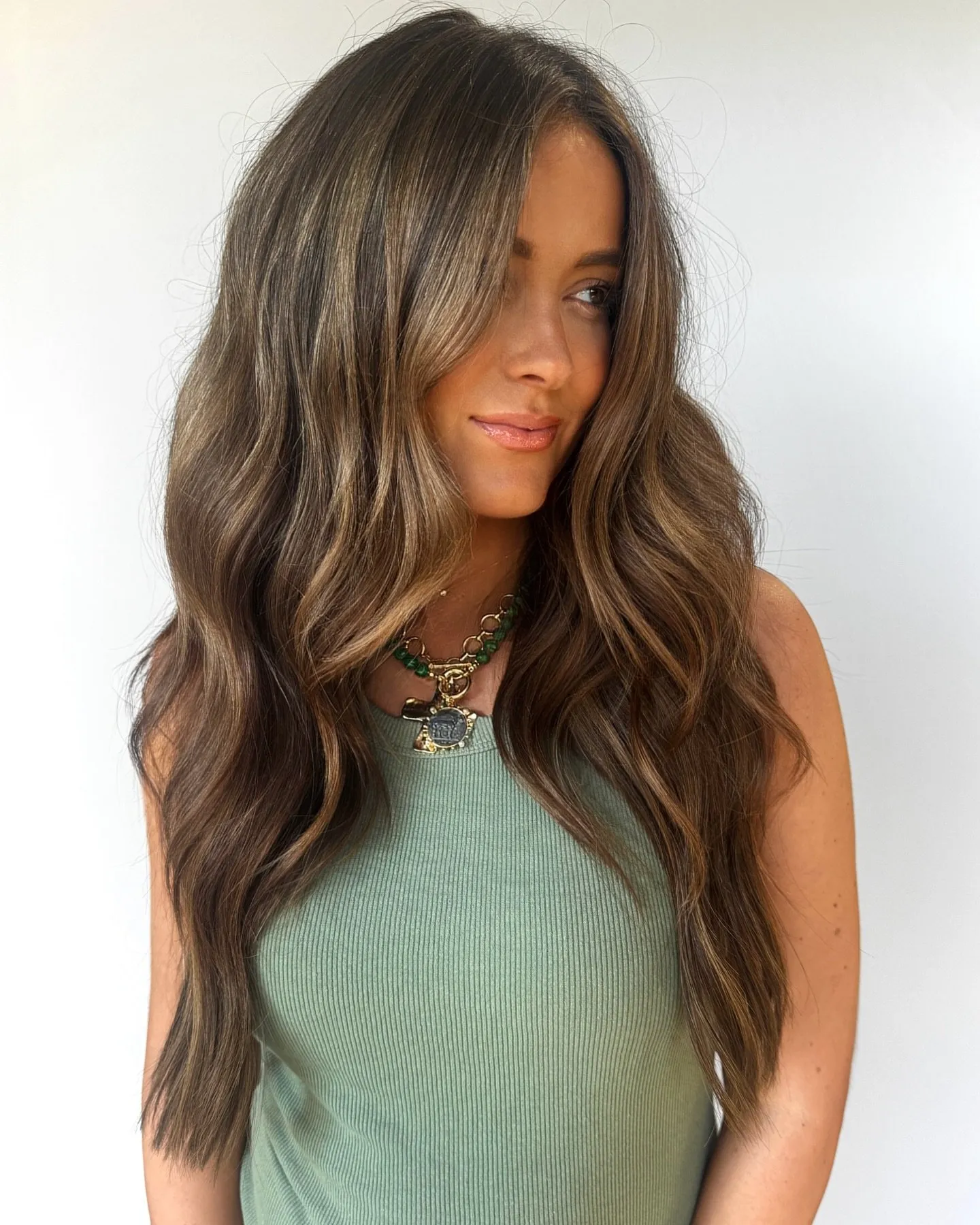 Capelli lunghi castani e mossi con morbide schiariture in stile francese, concentrate sulle lunghezze e sulle punte