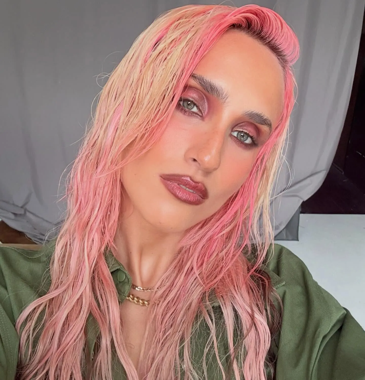 Lunghi capelli rosa mossi con riflessi pesca e biondi, styling effetto bagnato, ritratto estivo in stile editoriale