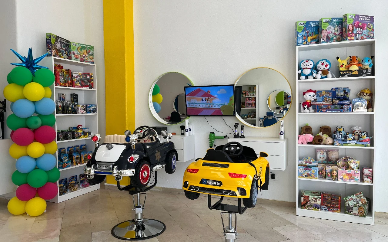 L'area bambini di Peluplay a Benalmádena, dove le poltrone hanno la forma di macchinine, con mensole piene di cartoni animati, specchi rotondi e una colonna di palloncini.