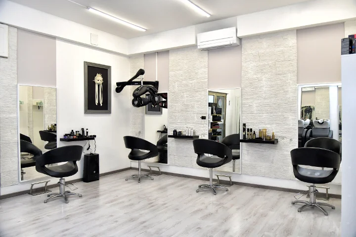 Postazioni di styling moderne da Sp Beauty di Serena Pinna vicino alle spiagge di Pittulongu a Olbia, con poltrone nere e grandi specchi.