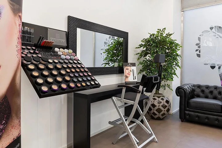Luminoso salone di manicure Top Estetica a Villanova, Cagliari, con parete turchese, banconi floreali e pavimenti in marmo.